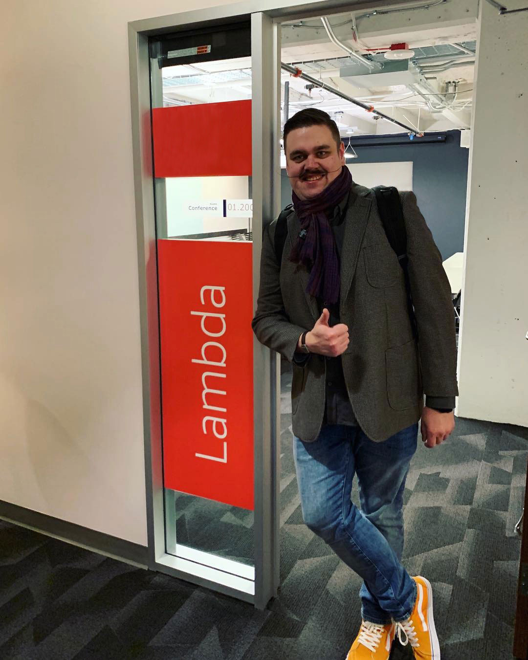 Ari on front of meeting room named “Lambda”